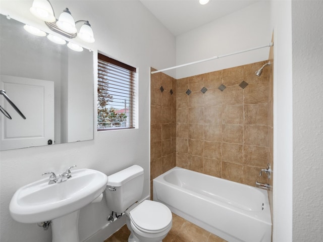 bathroom featuring tile patterned flooring, a sink, bathing tub / shower combination, and toilet