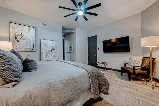 bedroom featuring light wood-type flooring, baseboards, visible vents, and a ceiling fan