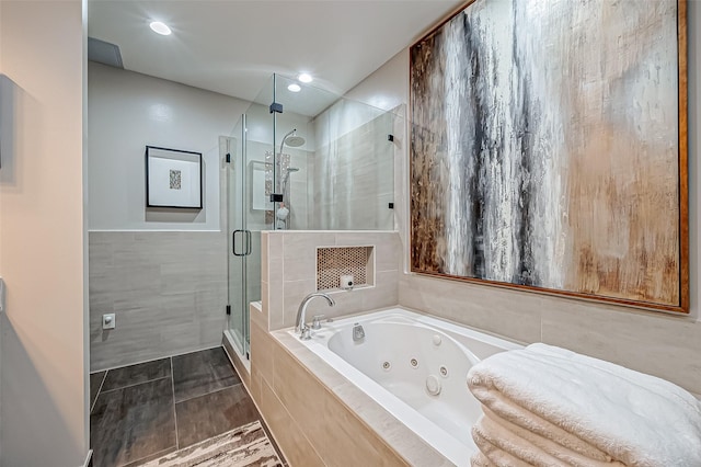505 Bastrop St Unit 508, Houston, TX 77003 - bathroom with tile walls, a tub with jets, a stall shower, and recessed lighting