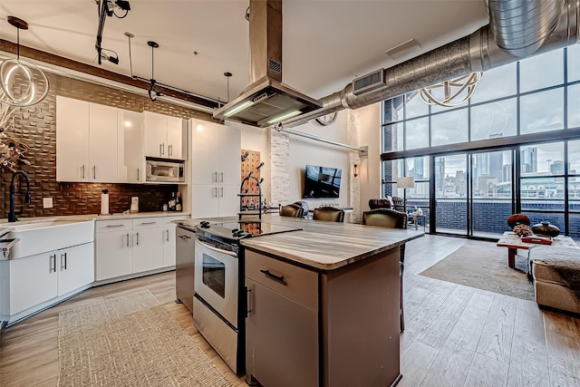 505 Bastrop St Unit 508, Houston, TX 77003 - kitchen with open floor plan, stainless steel appliances, expansive windows, a towering ceiling, and tasteful backsplash