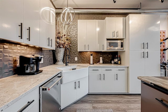 505 Bastrop St Unit 508, Houston, TX 77003 - kitchen featuring appliances with stainless steel finishes, a sink, backsplash, and white cabinets