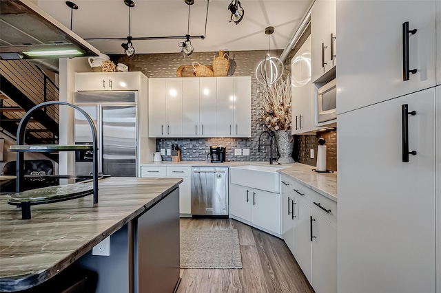 505 Bastrop St Unit 508, Houston, TX 77003 - kitchen featuring a sink, appliances with stainless steel finishes, white cabinetry, and wood finished floors