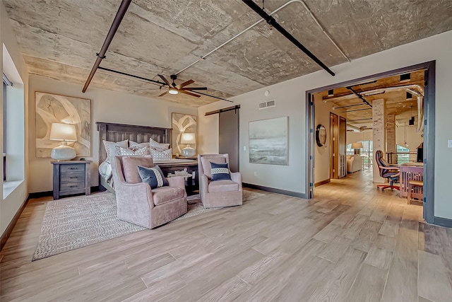 505 Bastrop St Unit 508, Houston, TX 77003 - bedroom featuring wood finished floors, a barn door, and baseboards