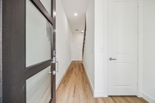 corridor featuring stairway, light wood-style flooring, baseboards, and recessed lighting