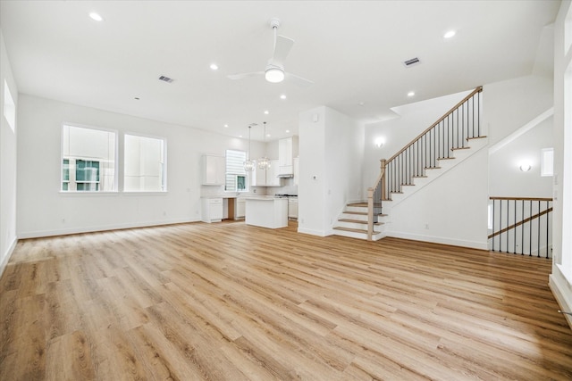 unfurnished living room featuring ceiling fan, recessed lighting, baseboards, and light wood-style floors