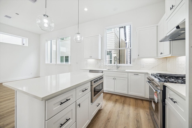 kitchen featuring white cabinets, stainless steel appliances, a sink, and light countertops