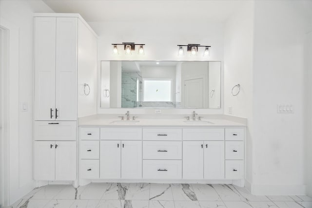 bathroom with double vanity, marble finish floor, and a sink