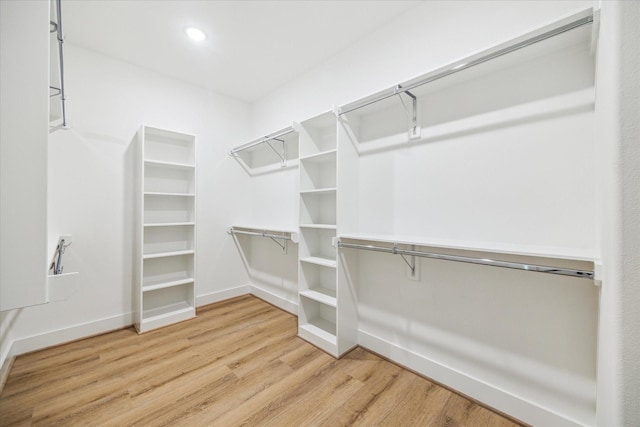 walk in closet with wood finished floors