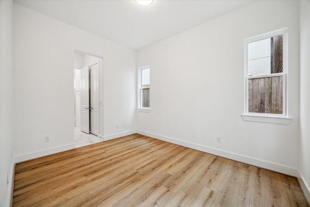 spare room with light wood-type flooring and baseboards