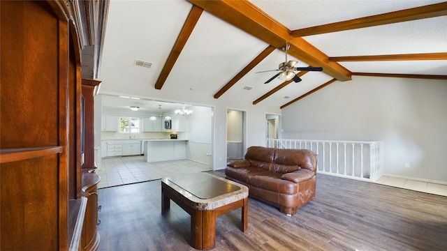 living area with lofted ceiling with beams, visible vents, a chandelier, and wood finished floors