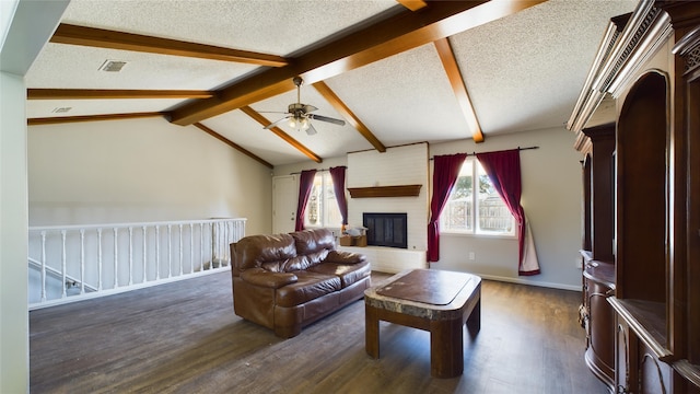 living room featuring visible vents, dark wood-style flooring, vaulted ceiling with beams, a textured ceiling, and a brick fireplace