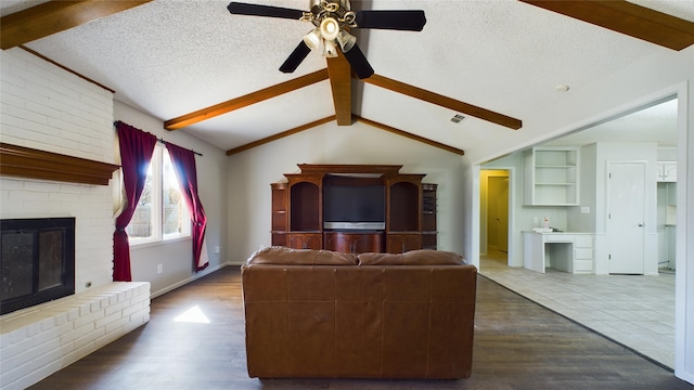 unfurnished living room featuring dark wood-style floors, a fireplace, visible vents, lofted ceiling with beams, and a textured ceiling