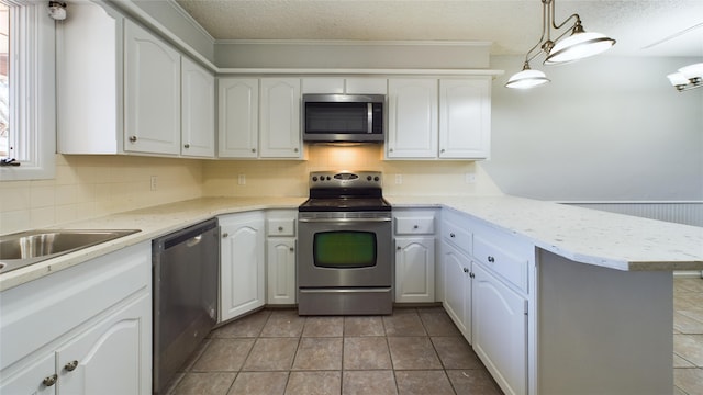 kitchen featuring a peninsula, appliances with stainless steel finishes, white cabinets, and light countertops