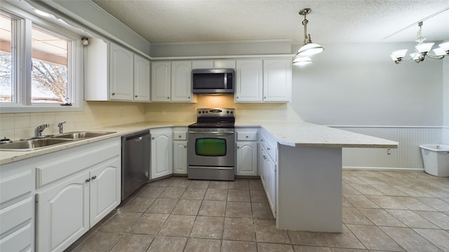 kitchen featuring appliances with stainless steel finishes, white cabinets, and light countertops