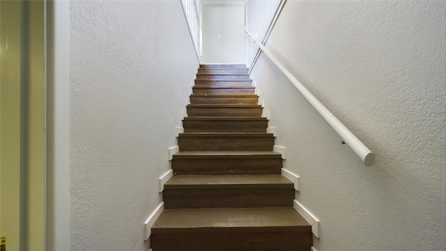 stairs featuring a textured wall