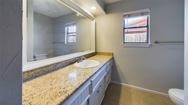 bathroom with toilet, tile patterned flooring, baseboards, and vanity