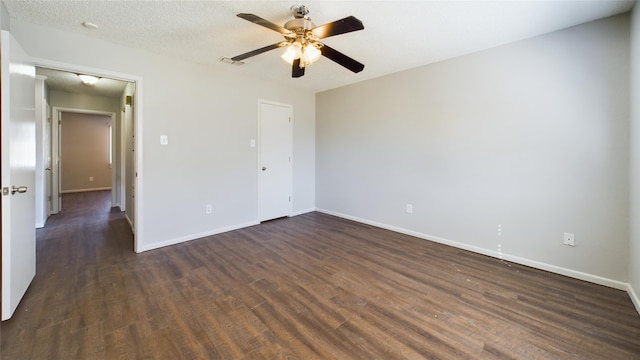 unfurnished room featuring baseboards, a textured ceiling, visible vents, and dark wood-type flooring