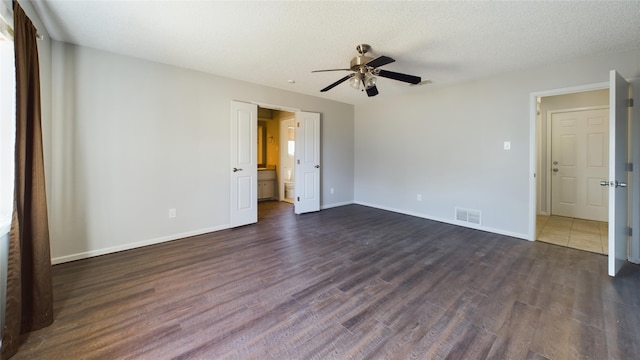 unfurnished bedroom with dark wood finished floors, visible vents, a ceiling fan, a textured ceiling, and baseboards