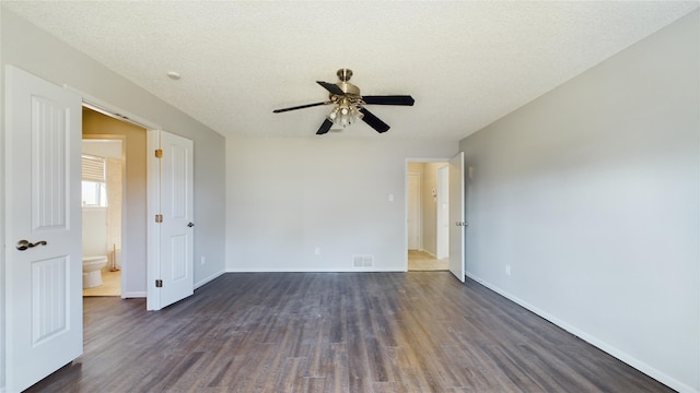 empty room featuring dark wood finished floors, visible vents, and baseboards