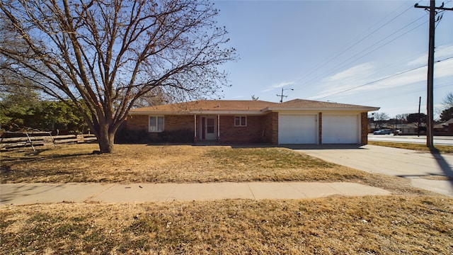 ranch-style house with a garage, brick siding, fence, concrete driveway, and a front lawn