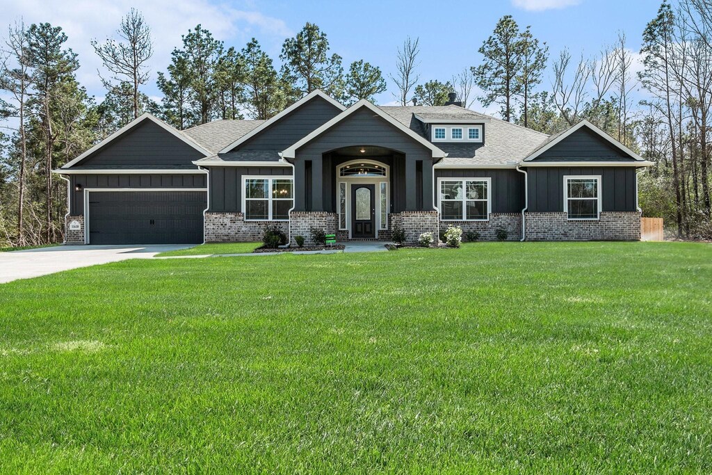 11610 Wilgers Way, Willis, TX 77378 - craftsman-style house with board and batten siding, an attached garage, and a front lawn