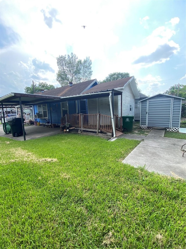 back of house with a shed, an outdoor structure, and a yard