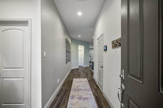 hall featuring recessed lighting, dark wood finished floors, and baseboards