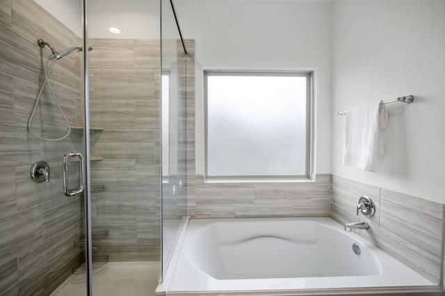 full bathroom featuring a stall shower and a garden tub