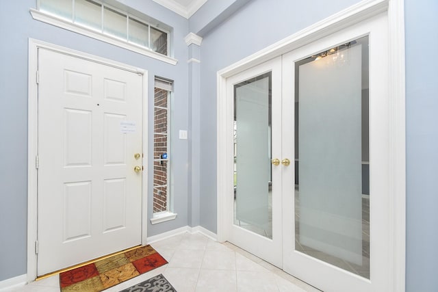 entryway featuring light tile patterned floors, baseboards, ornamental molding, and french doors