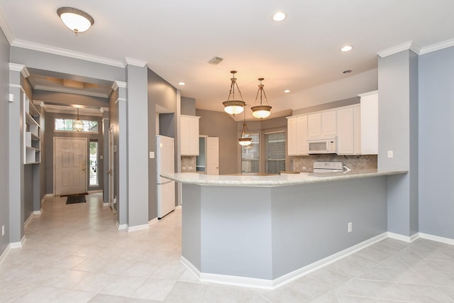 kitchen featuring white appliances, white cabinets, decorative light fixtures, a peninsula, and light countertops