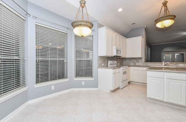 kitchen with white appliances, white cabinetry, pendant lighting, and decorative backsplash