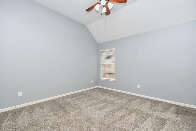 carpeted empty room featuring vaulted ceiling, ceiling fan, and baseboards