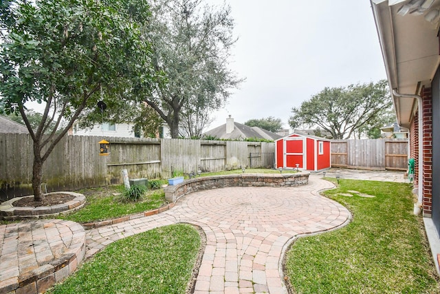 view of patio with a shed, a fenced backyard, and an outbuilding