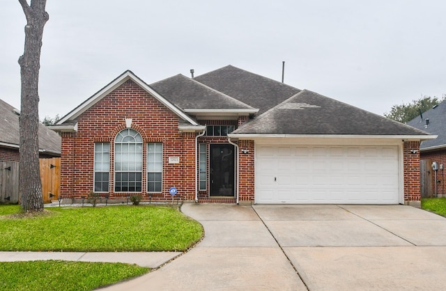 view of front of home with an attached garage, brick siding, a shingled roof, driveway, and a front lawn