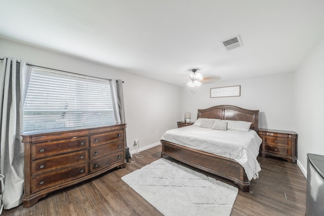 bedroom with dark wood-style floors, visible vents, baseboards, and a ceiling fan