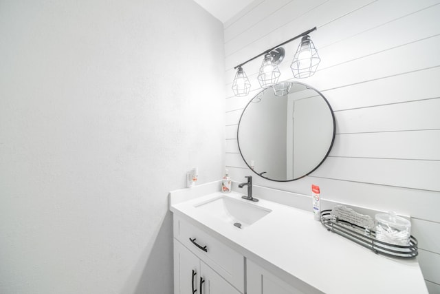 bathroom with vanity and wooden walls