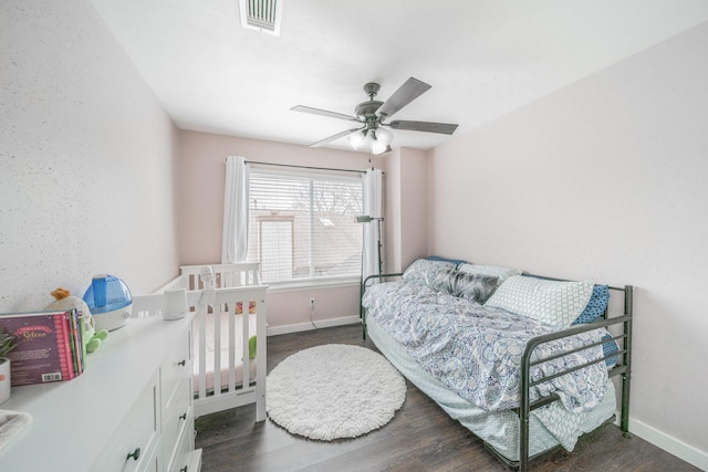 bedroom with visible vents, baseboards, dark wood finished floors, and a ceiling fan