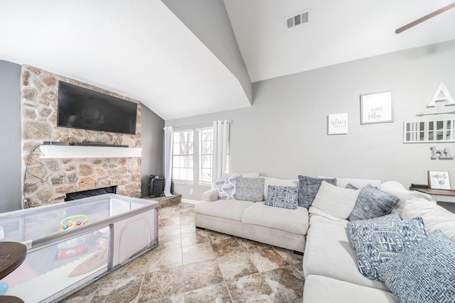 living area featuring lofted ceiling, visible vents, a fireplace, and baseboards