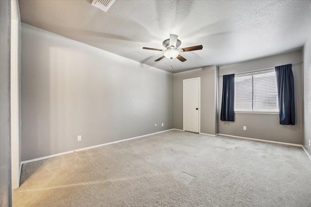 unfurnished room with ceiling fan, visible vents, baseboards, and light colored carpet