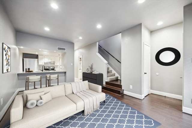 living room featuring stairs, visible vents, dark wood-type flooring, and recessed lighting