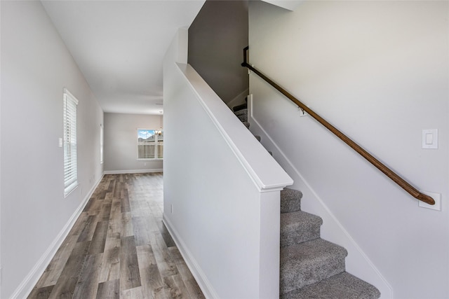 staircase featuring wood finished floors and baseboards