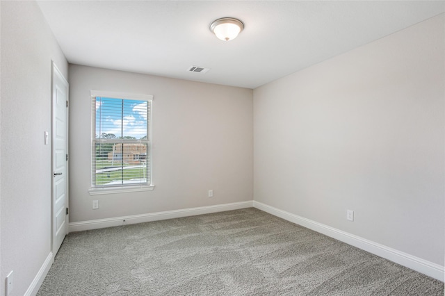 unfurnished room with baseboards, visible vents, and light colored carpet