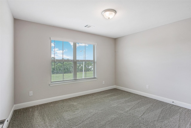 carpeted spare room featuring visible vents and baseboards