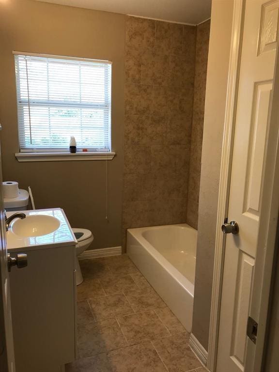 bathroom with baseboards, vanity, toilet, and shower / bathtub combination