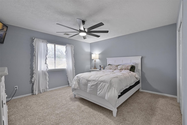 bedroom with visible vents, a textured ceiling, baseboards, and carpet