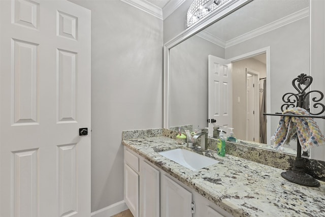 bathroom with baseboards, ornamental molding, and vanity