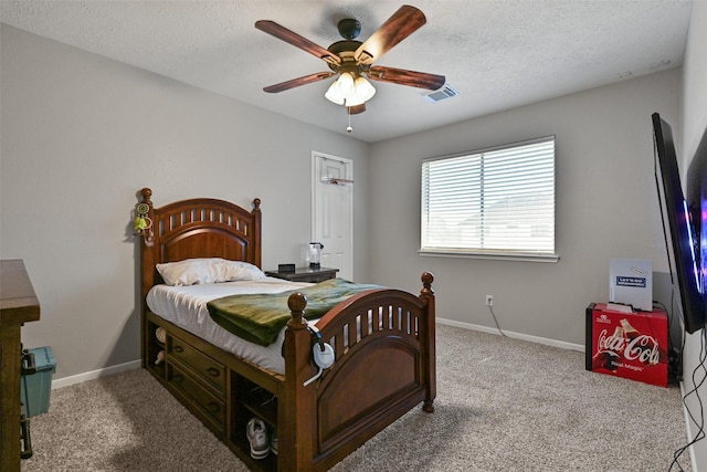 carpeted bedroom with visible vents, baseboards, a textured ceiling, and ceiling fan