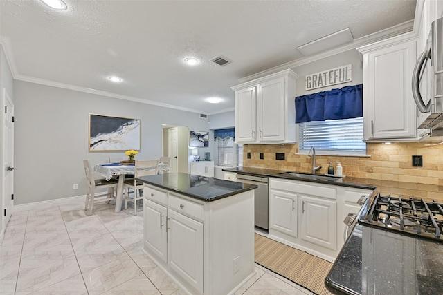 kitchen with a sink, tasteful backsplash, stainless steel dishwasher, a center island, and white cabinetry