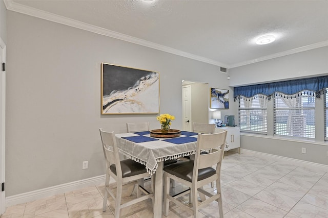 dining room with marble finish floor, crown molding, and baseboards