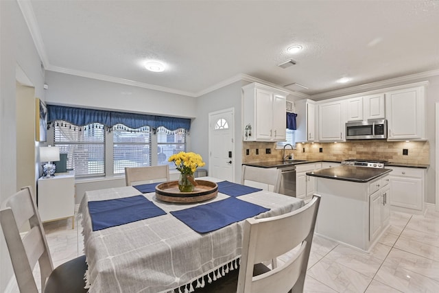 kitchen featuring dark countertops, visible vents, appliances with stainless steel finishes, white cabinetry, and a sink